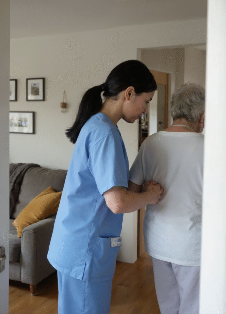 Carer gently assisting an older person with walking inside a cosy home – respite care in Christchurch and Tauranga