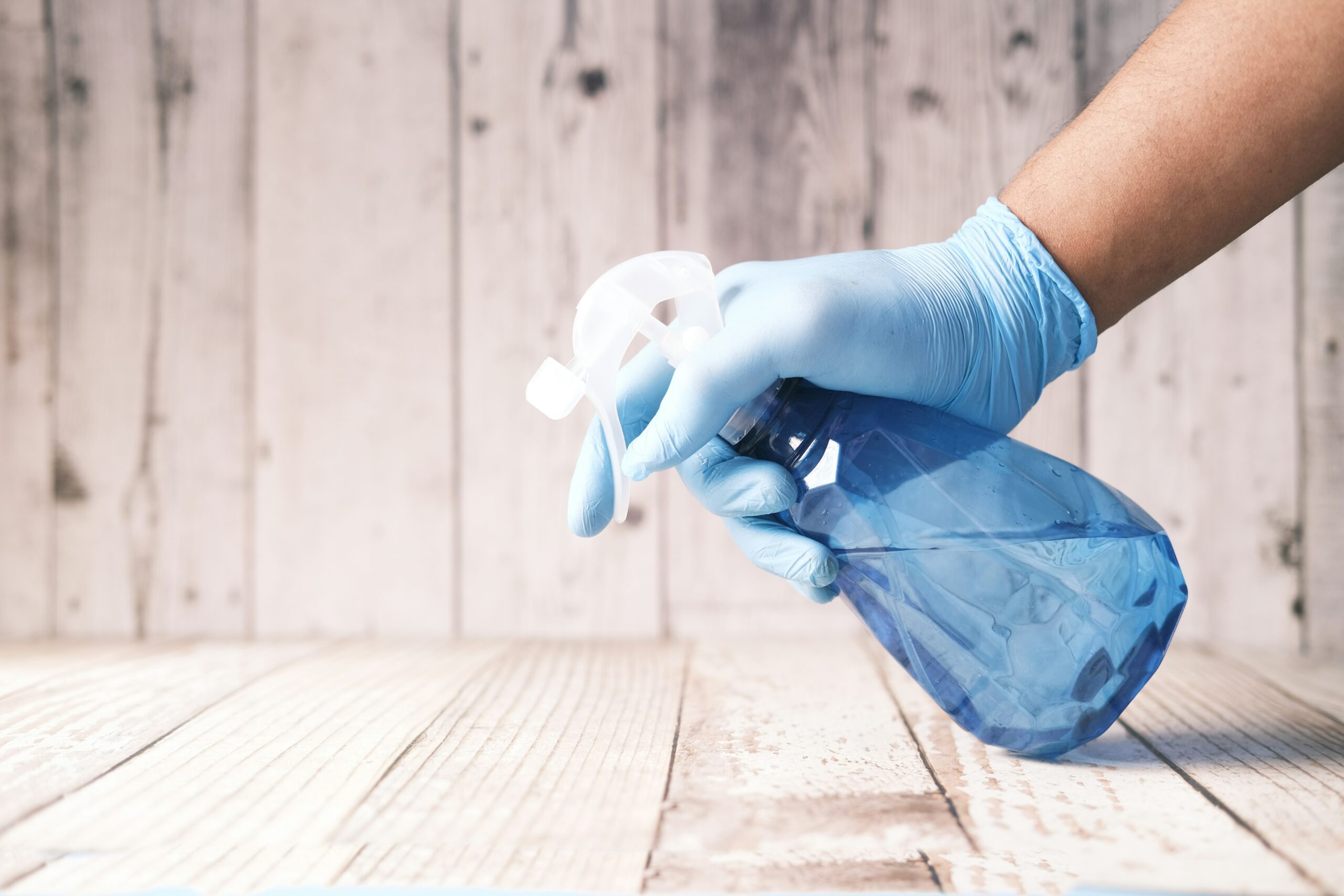Cleaner wiping down a kitchen counter with natural sprays – eco-friendly cleaning services for older people in Christchurch and Tauranga