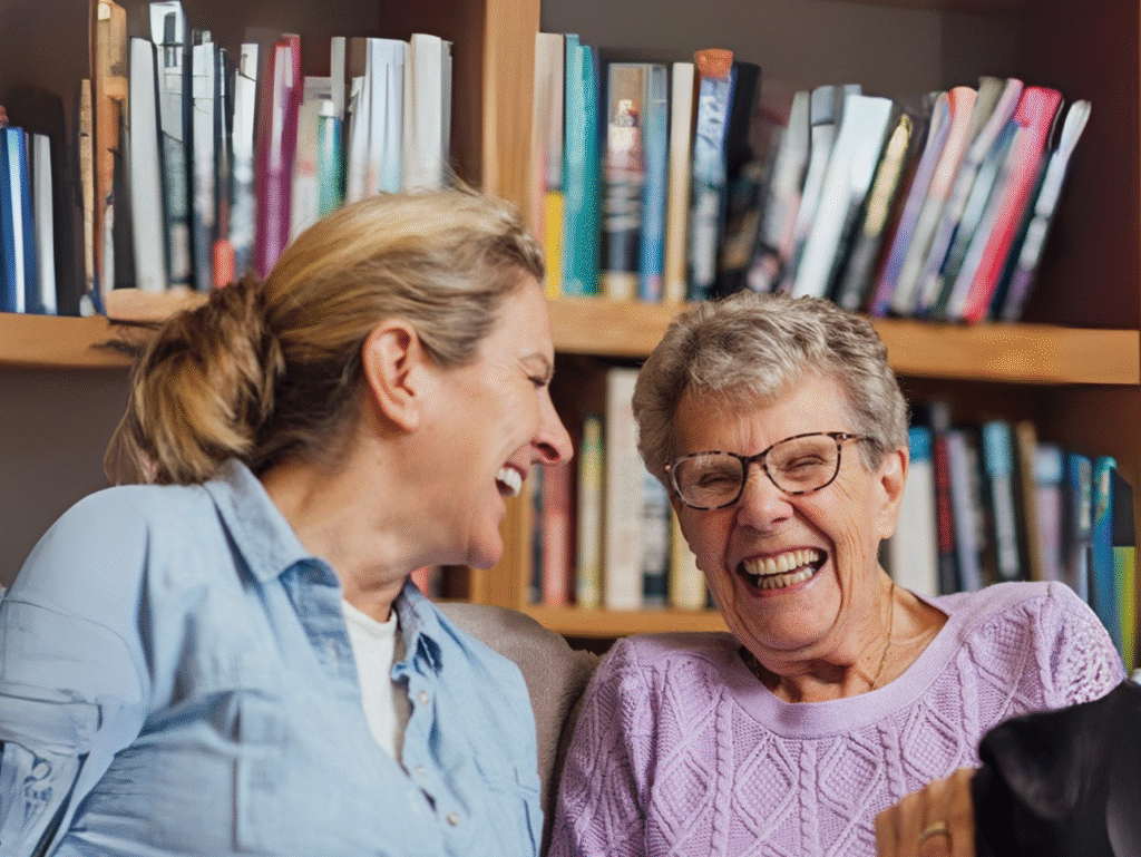 Carer chatting with and gently supporting an older person inside a cosy New Zealand home – respite care in Christchurch and Tauranga