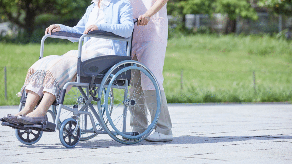 Caregiver assisting an older person in a wheelchair outdoors – dementia care for older people in Christchurch and Tauranga