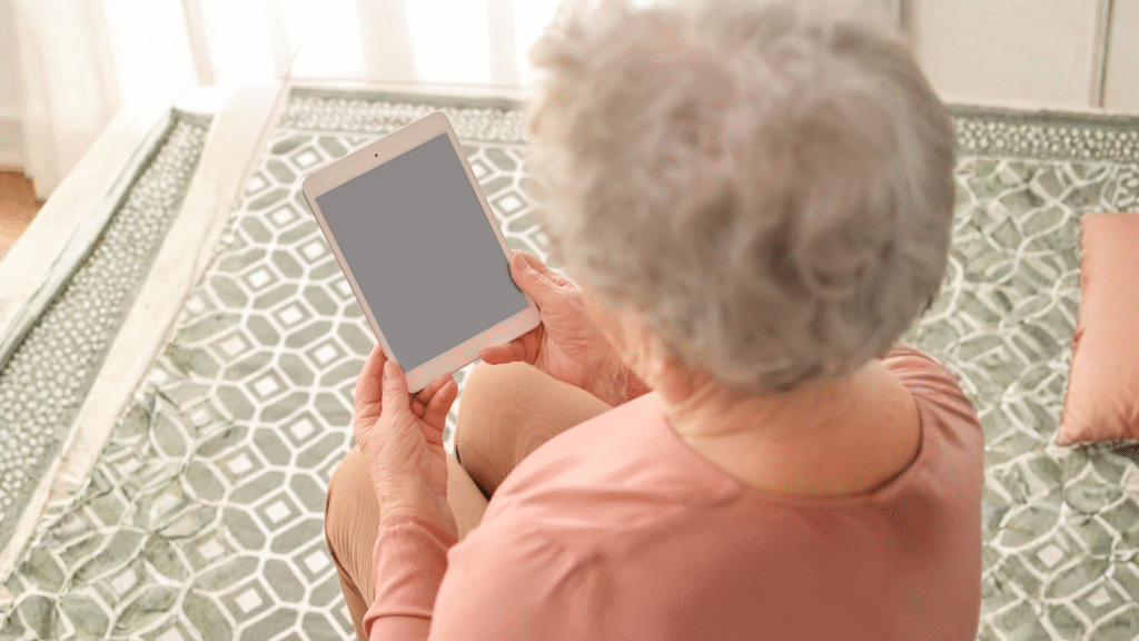 Older person using a tablet at home to stay connected and supported – dementia care for older people in Christchurch and Tauranga