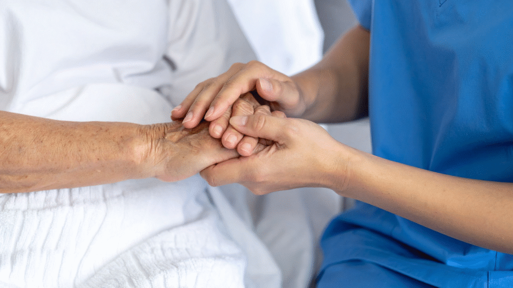 Caregiver gently holding an older person’s hands after hospital discharge – hospital to home care for older people in Christchurch and Tauranga