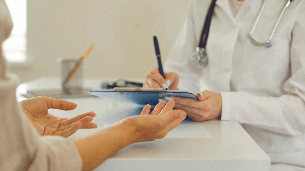 Doctor writing notes during a medical appointment with a patient in Christchurch, New Zealand