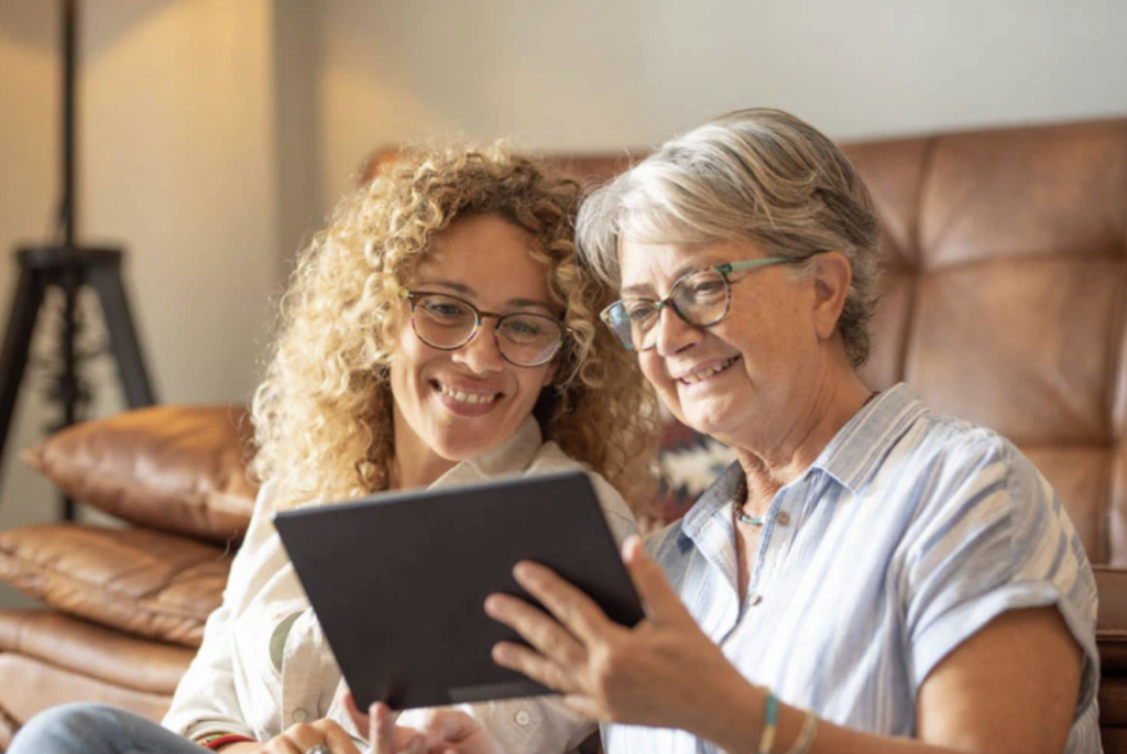 Carer helping an older woman use a tablet with easy-to-use technology from Big Buttons Tauranga